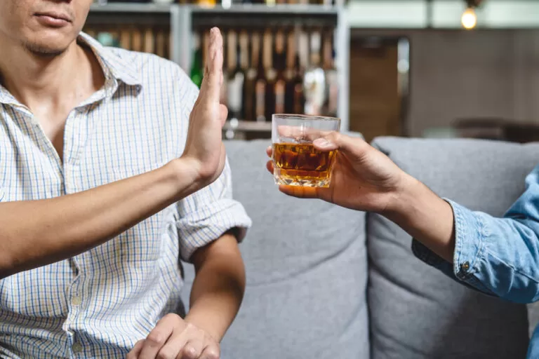 Stoppen met alcohol door nee te zeggen. Man weiger drank aan te nemen.
