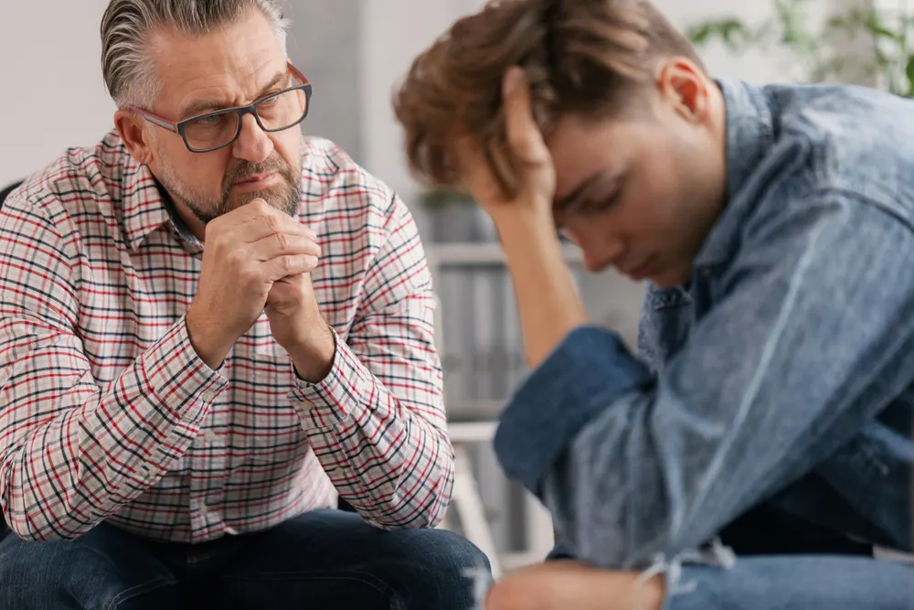 Iemand die via een laptop een gesprek voert over zijn verslaving